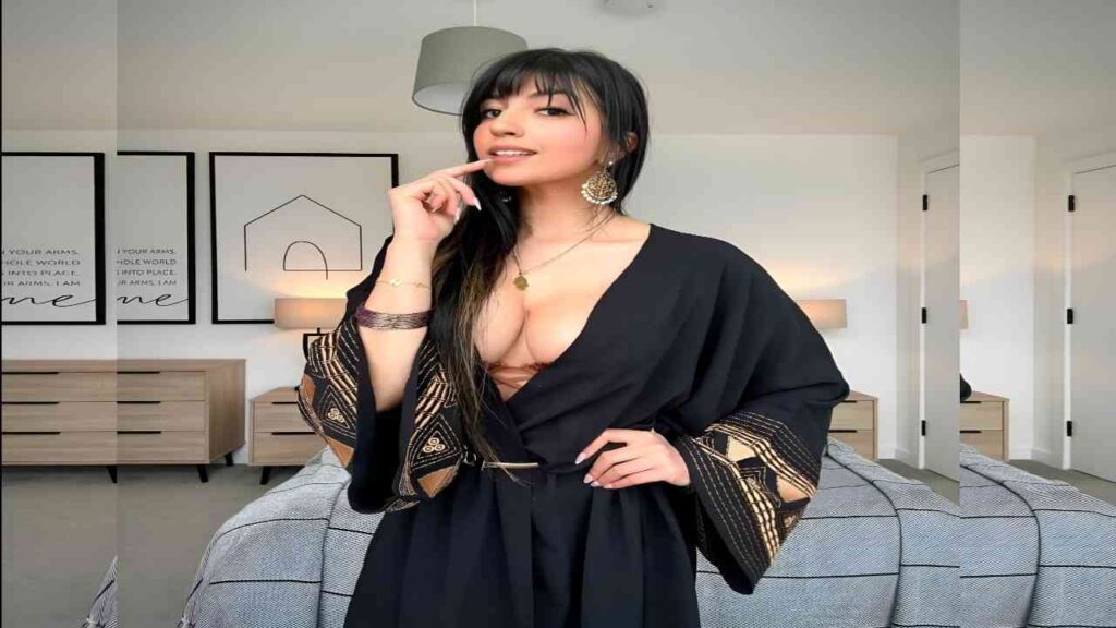 Aaliyah Yasin in a black robe poses for a photo, smiling confidently at the camera.
