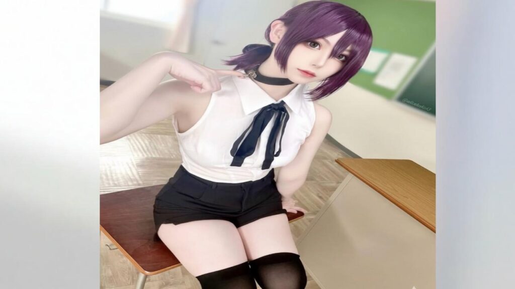 AliceHolic13 with purple hair wearing black stockings sits elegantly on a chair.
