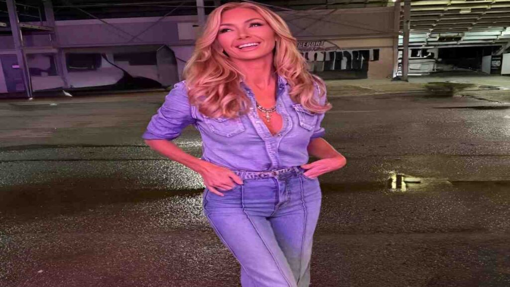 Brande Roderick wearing a denim shirt and jeans stands confidently, showcasing a casual and stylish outfit