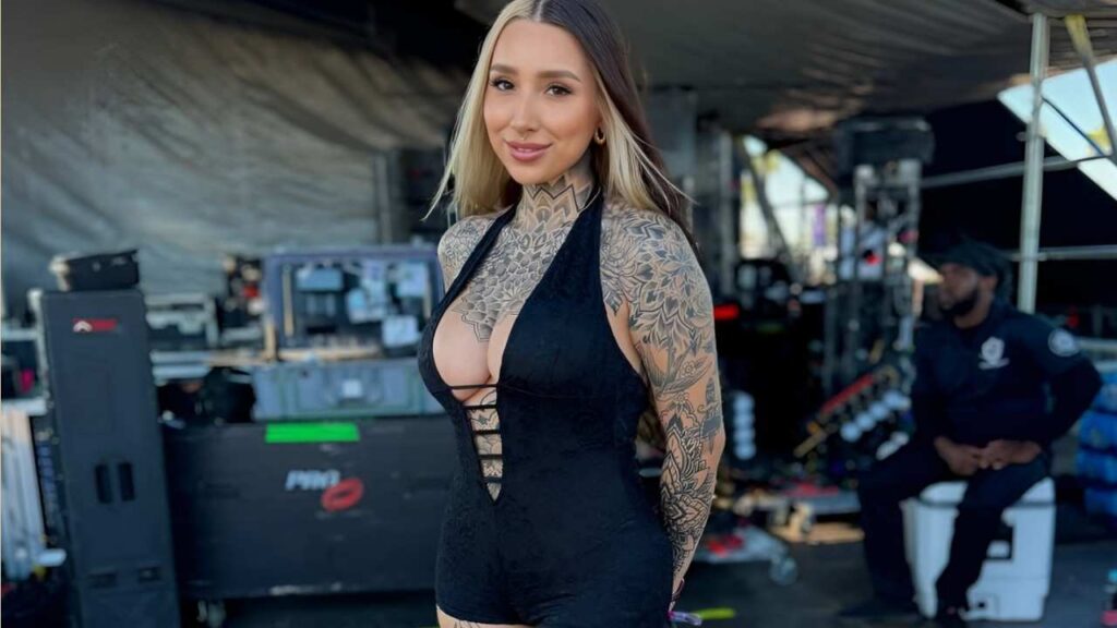 Bri Uvina with visible tattoos poses confidently for a photo, showcasing her body art and unique style