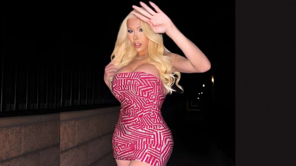 Brittney Kade woman in a short dress poses confidently for a photograph, smiling at the camera