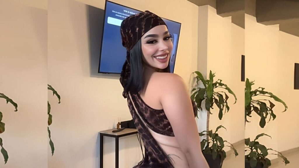 Camila Henao poses for a picture, wearing a stylish leopard print dress, showcasing her confident demeanor