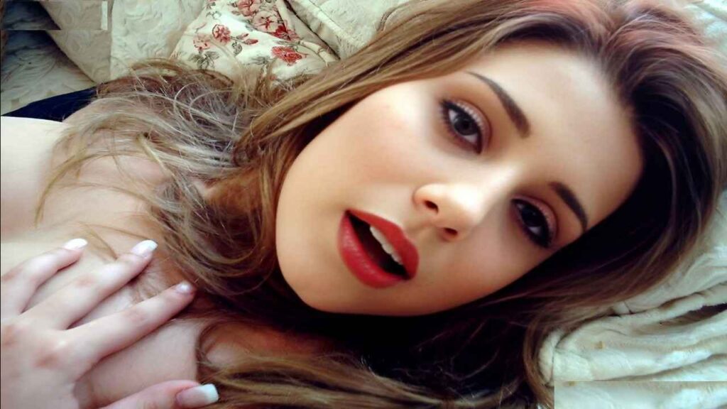 Erica Campbell reclining on a bed, with soft lighting highlighting her serene expression