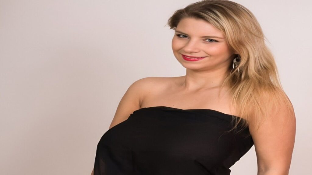 Katerina Hartlova blonde woman wearing an elegant black dress, posing gracefully with a confident expression