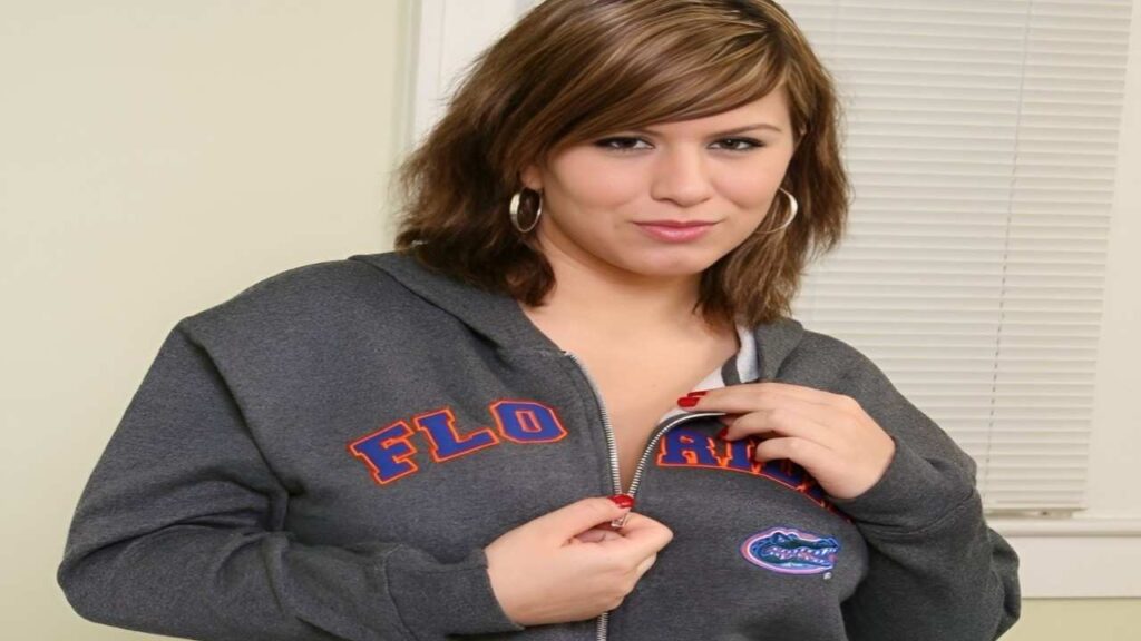 London Andrews wearing a Florida Gators hoodie stands smiling, showcasing her support for the university's sports team