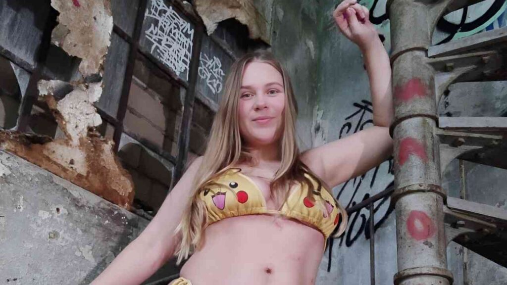 Maja Meer in a bikini poses confidently on a staircase, showcasing a stylish summer look.