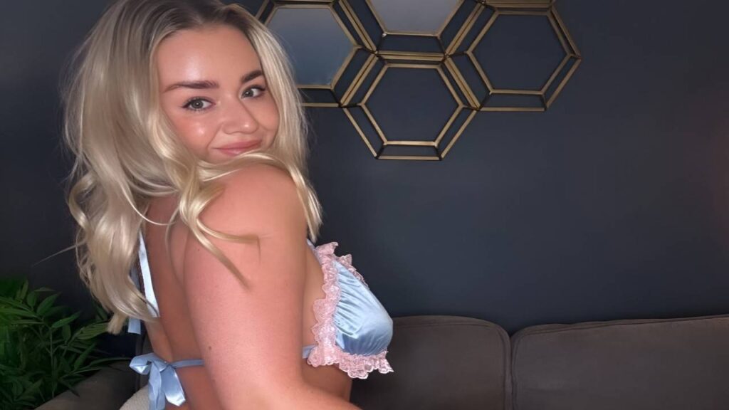 Melissa Debling wearing a blue lingerie top, posing confidently against a neutral background.