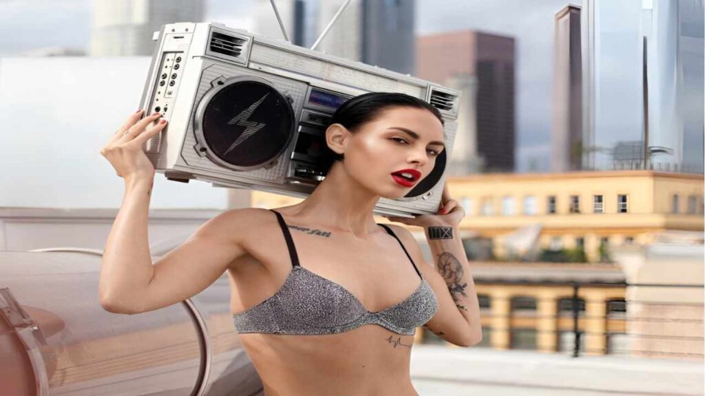Alyssa Arce in lingerie holds a boombox, exuding confidence and a playful spirit.