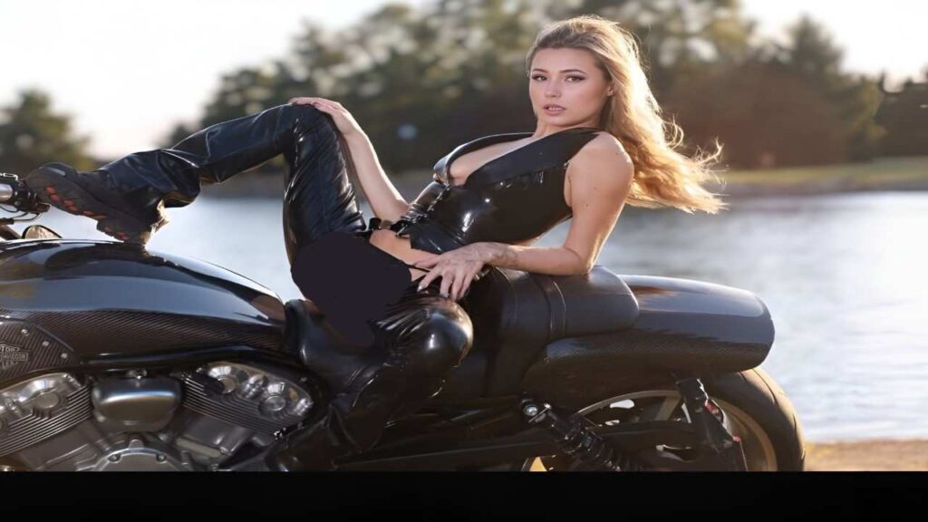 Carolina Sweets in a leather outfit confidently sits on a motorcycle, showcasing a bold and adventurous style