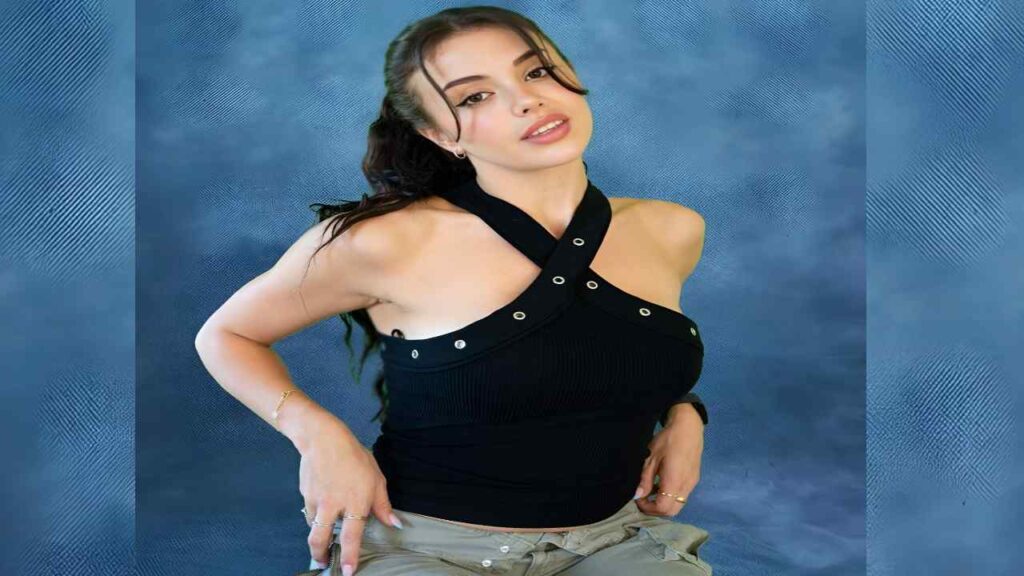 Emily Black in a black top and jeans poses confidently, showcasing her style and demeanor.