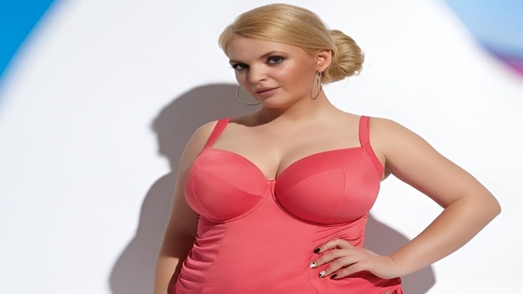 Ines Cudna in a pink swimsuit poses confidently for the camera, showcasing her vibrant swimwear against a bright background