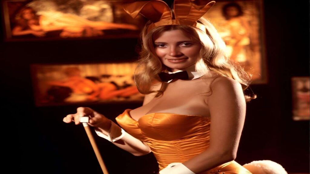 Janet Lupo in a bunny costume holds a stick, smiling playfully in a colorful outdoor setting.