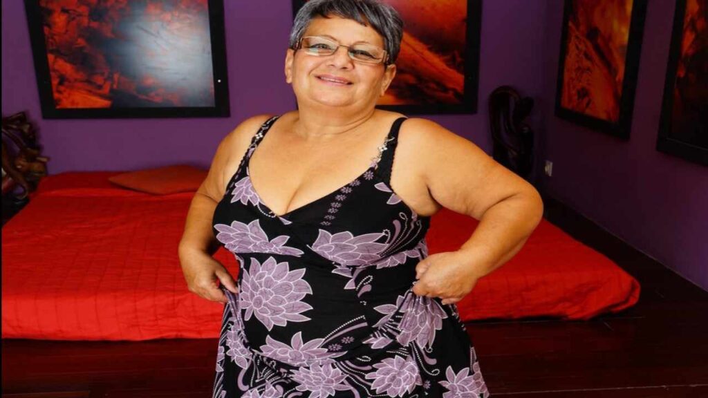 Mariette Hartley in a stylish dress poses confidently for the camera, showcasing her outfit and smile