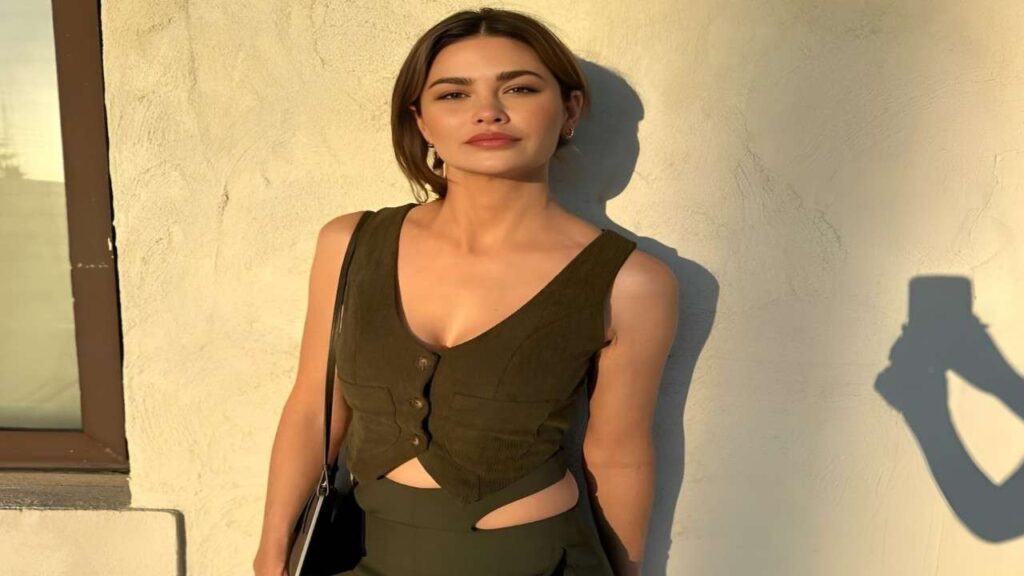 Megan Marx poses confidently in green pants and a matching top, showcasing her stylish outfit.