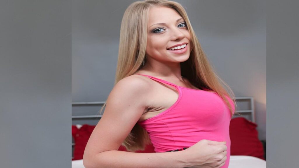 Shawna Lenee wearing a pink tank top, smiling and looking confidently at the camera.