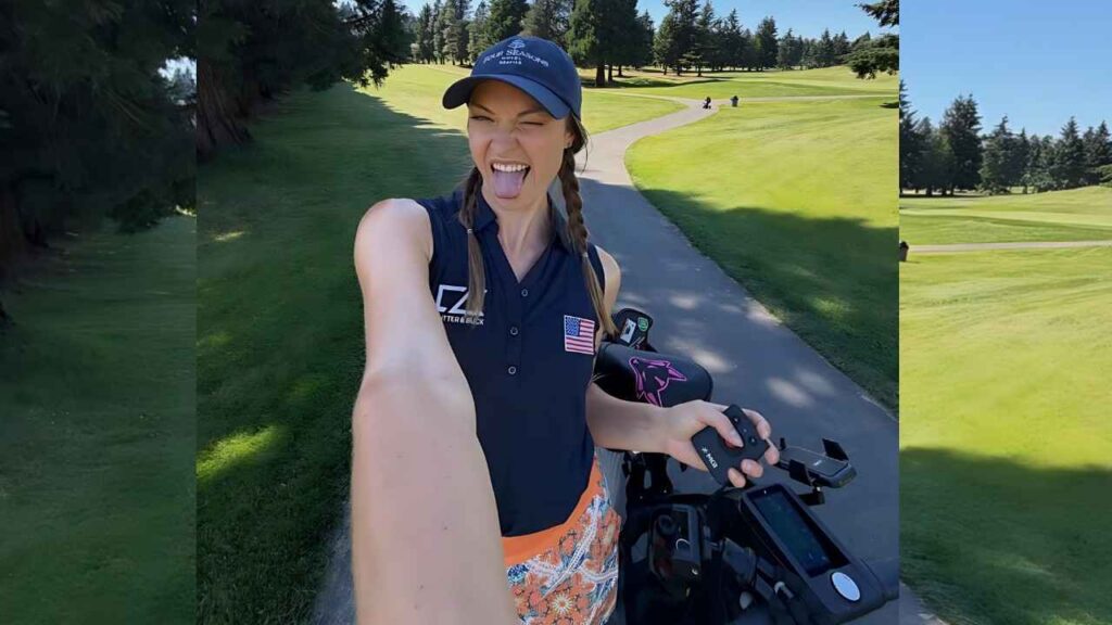 India Gants Selfie on a golf course: tongue out, navy polo with USA flag patch, braided pigtails, cap, orange floral shorts beside cart.