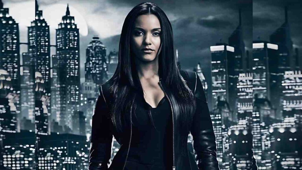 Jessica Lucas with long, straight black hair in a black leather jacket stands before a glowing, blue-tinted city skyline at night.