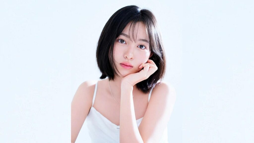 Kal So-won with a sleek black bob rests her chin on her hand, wearing a white spaghetti-strap top, gazing at the camera.