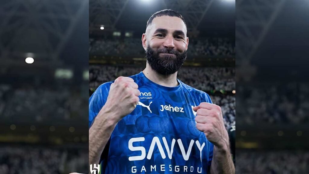 Karim Benzema in a blue jersey featuring Savvy Games Group and jahez raises fists in celebration amid a packed stadium.