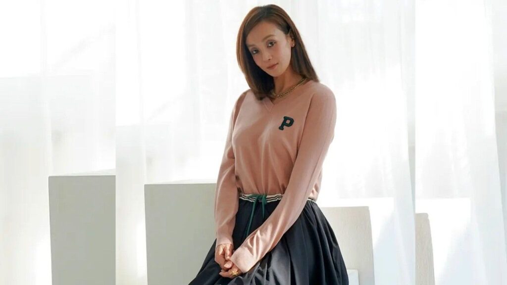 Kwon Min-jung (권민중) with a young woman seated, wearing a pink sweater with a P, a black skirt and a green belt.