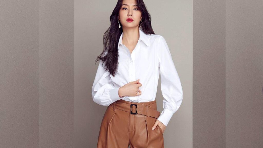 Seo Ji-young (서지영) in a white shirt and high-waisted tan leather pants with a wide belt, posing against a neutral backdrop.