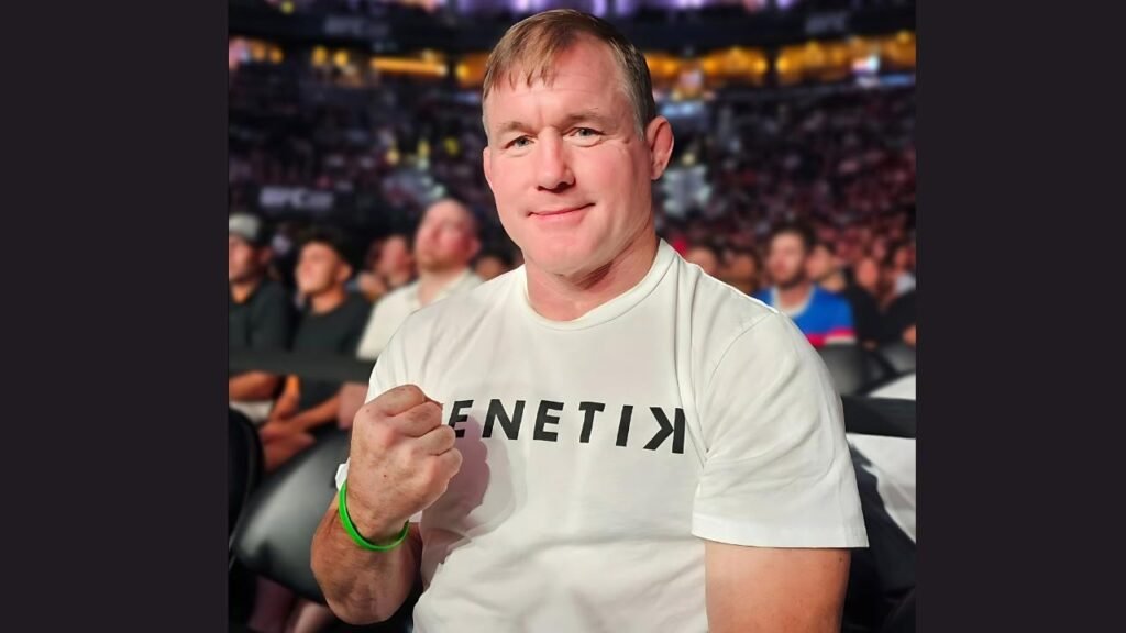 Matt Hughes wearing a white shirt featuring the name "Ken" prominently displayed on the front.