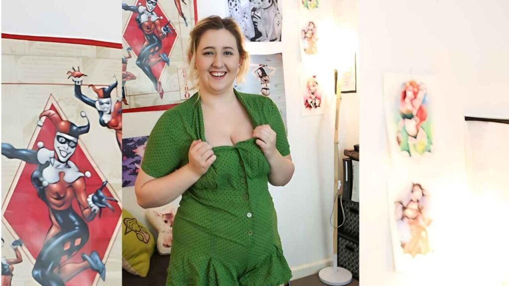 Mikki Mischief in a green polka-dot romper stands in an art-filled room, adjusting the neckline while surrounded by posters and sketches.