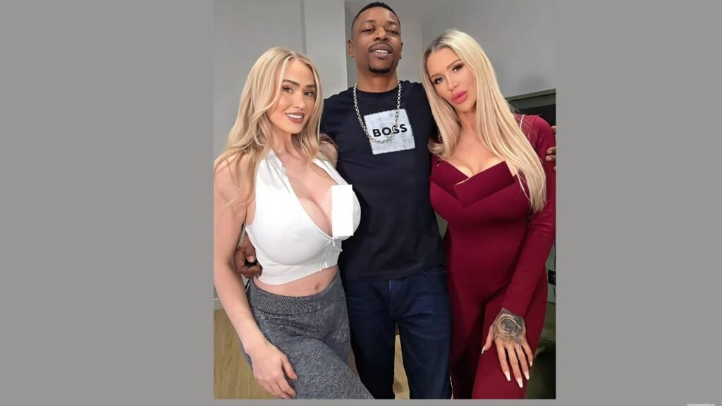 Mr Longwood in black Boss tee between two Women, one in white crop top, the other burgundy dress, smiling.