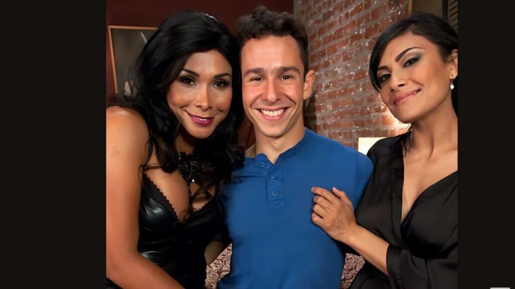 Three friends pose indoors against a brick wall: two women flanking a smiling Nathan Styles in a blue polo, close and cheerful.
