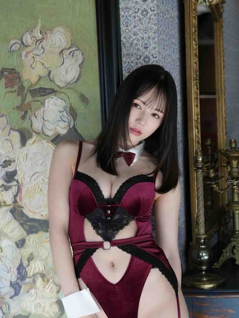 Remu Suzumori in burgundy velvet with black lace trim, white collar bow, leaning against ornate floral wallpaper.