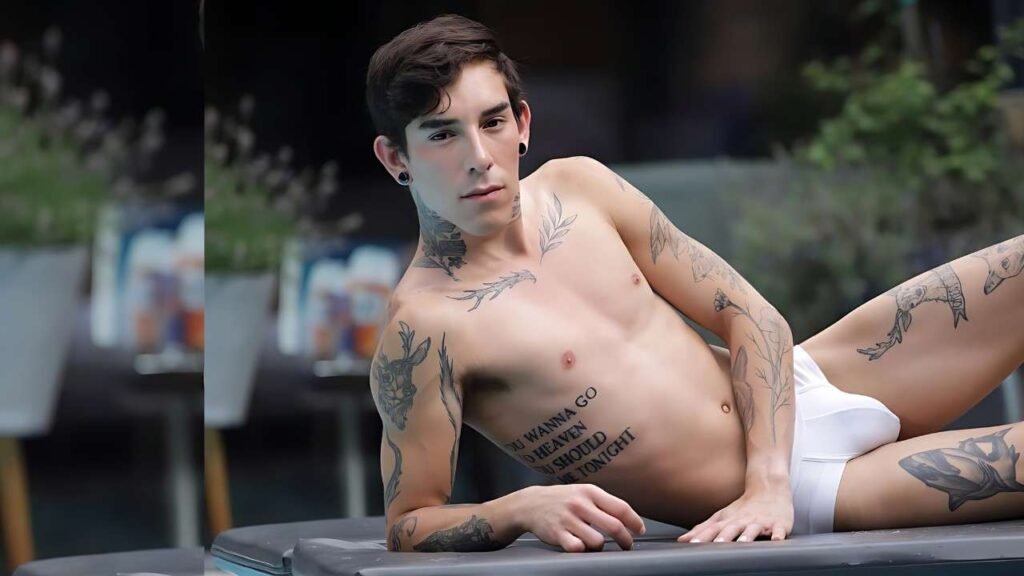 Roman Capellini with numerous chest and arm tattoos reclines shirtless in white briefs on a poolside lounge, gazing ahead.