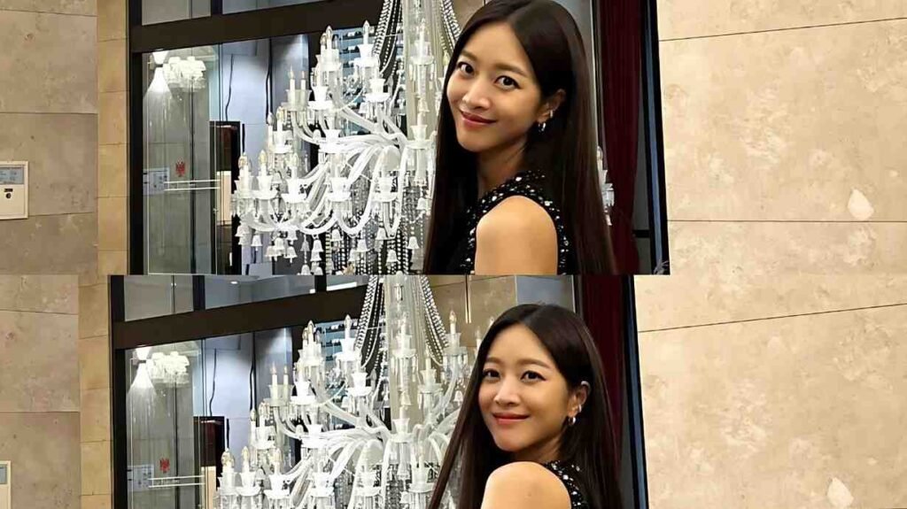 Cho Bo-ah ( 조보아 ) in a sparkly black dress beside a crystal chandelier against beige marble walls.