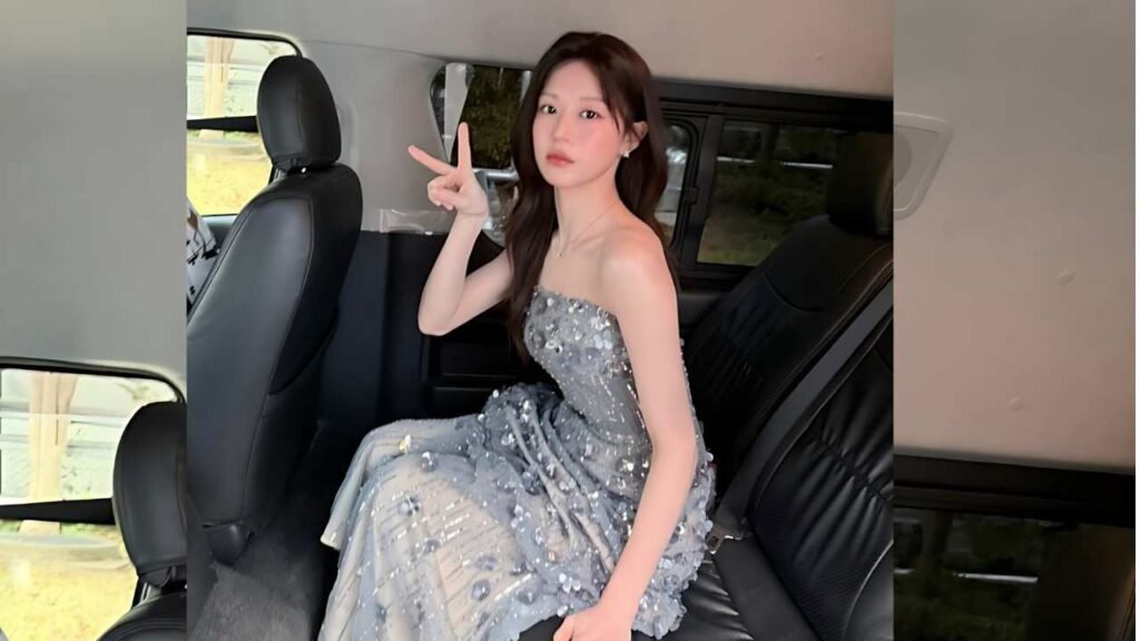 Go Youn-jung ( 고윤정 ) in a sparkly strapless silver gown sits in the back seat of a car, flashing a peace sign with her right hand.