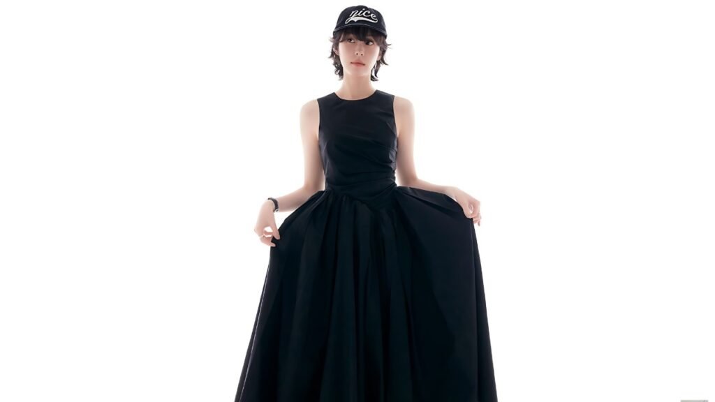 Seo Eun-soo in a sleeveless black gown holds the full skirt, wearing a black cap with white lettering against a backdrop.
