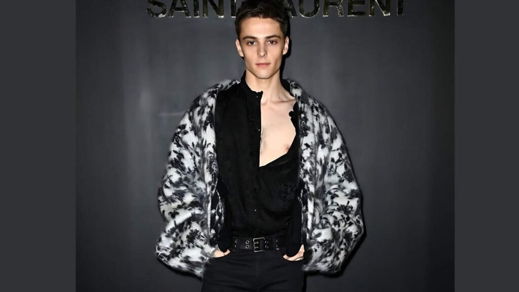 Corey Fogelmanis wearing a black shirt and black jacket, standing confidently with a neutral expression.