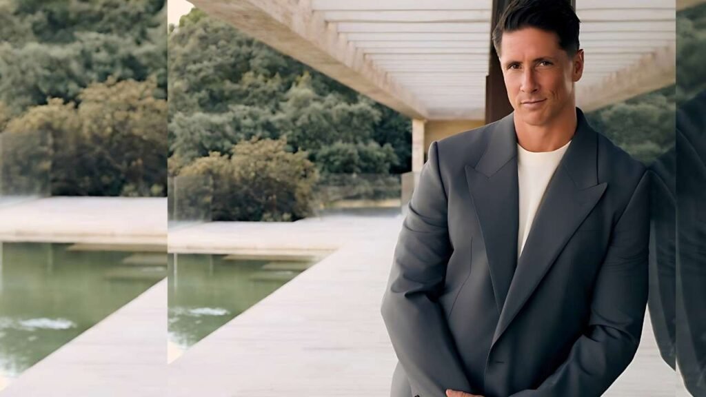 Fernando Torres in a suit stands beside a swimming pool, looking confidently at the camera.