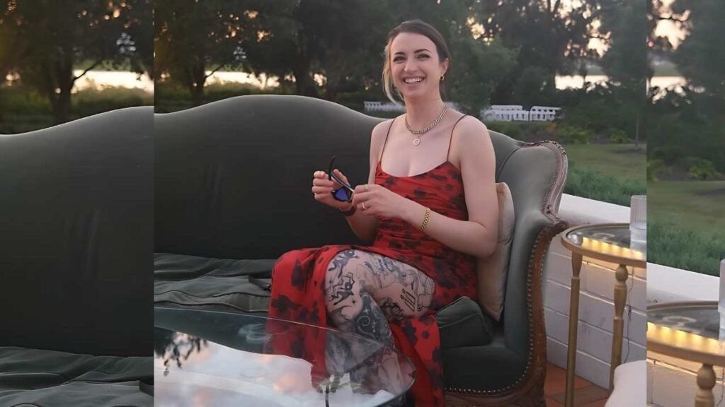 Gibi ASMR wearing a vibrant red dress is seated on a couch, showcasing a comfortable and fashionable pose.