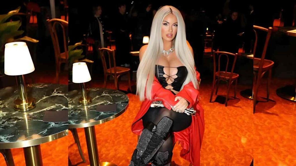Laci Kay Somers with long white hair is seated on a chair, looking thoughtfully into the distance.