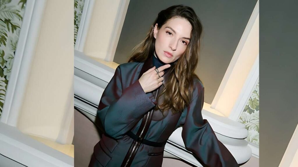 Maria Valverde wearing a black jacket and green pants stands confidently, showcasing a stylish outfit.