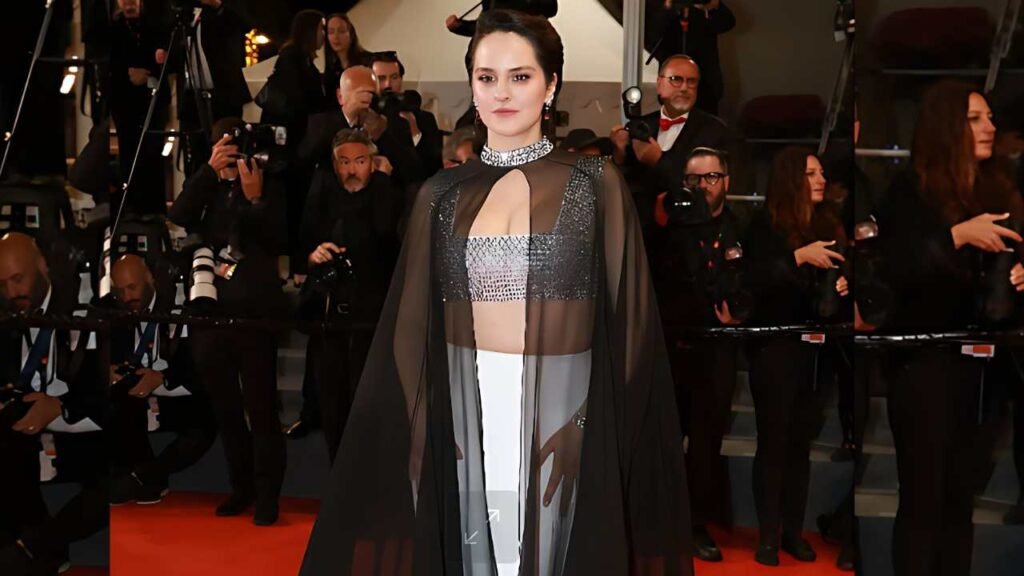 Noemie Merlant wearing a black and white gown poses elegantly at the Cannes Film Festival, showcasing glamour and style.