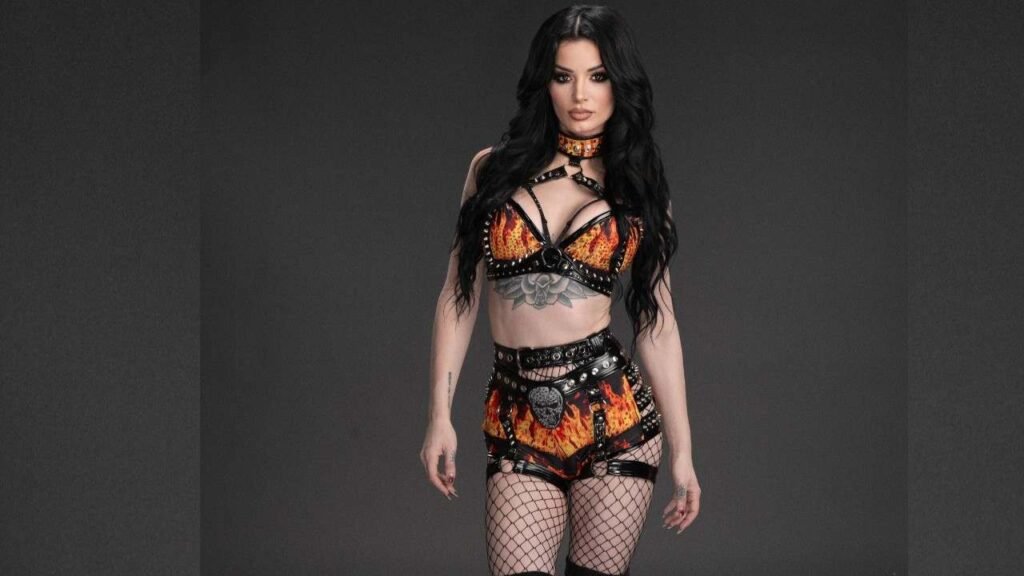 Saraya Bevis wearing a vibrant fire-themed outfit, featuring flames and bright colors, posing confidently
