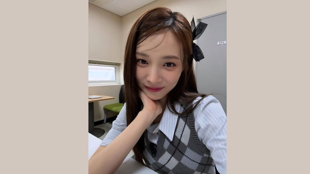 Yoon So Hee with long hair is seated at a table, engaged in conversation or contemplation.