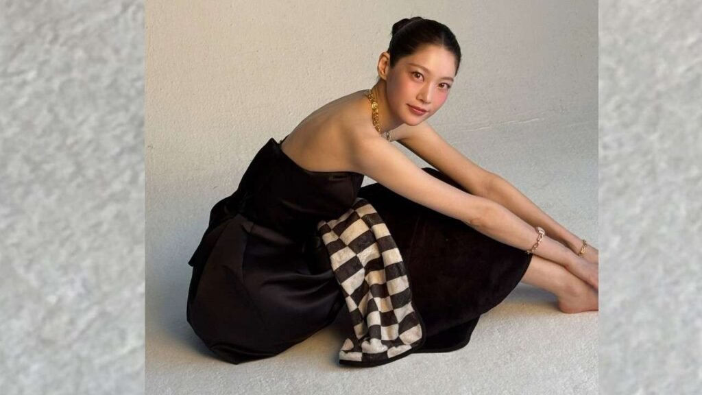 Gong Seung-yeon in a black dress sits gracefully on the floor, her expression contemplative and serene.