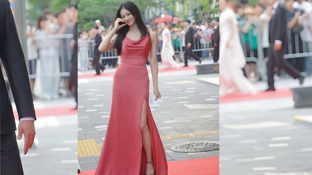 Han Ji-eun in a red dress walks confidently down a vibrant red carpet, showcasing elegance and style.